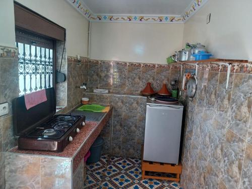 a kitchen with a stove and a small refrigerator at Dar rachid ouzoud in Azilal