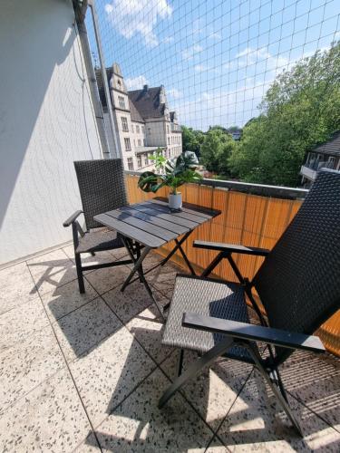 un patio con 2 sillas y una mesa en el balcón en Apartment nähe Düsseldorf Messe Expo, Airport, Train Station, en Duisburg