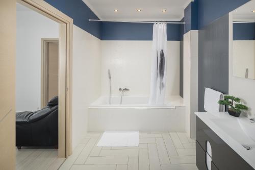 baño con paredes azules y blancas y bañera en Villa Alena, en Poreč