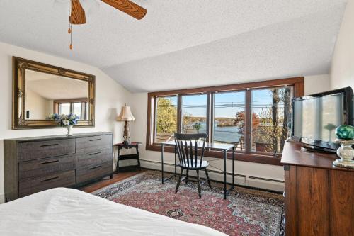 Schlafzimmer mit einem Bett, einem Schreibtisch und einem Spiegel in der Unterkunft Grammy's Lake House w Private Waterfront Access in East Hampton