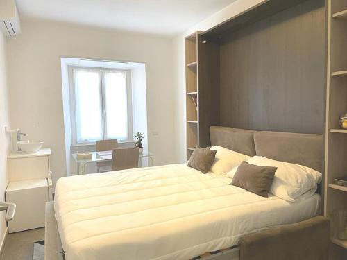 um quarto com uma grande cama branca e uma janela em Manfredi House San Pietro em Roma
