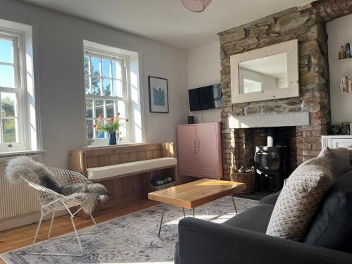 a living room with a couch and a fireplace at 2a Coastguard Cottages in Gorran Haven