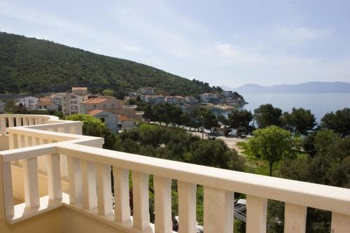 a balcony with a view of a town and the water at Hotel Bella Vista in Drvenik
