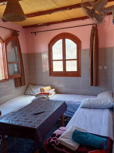 a room with two beds and a table at Dar rachid ouzoud in Azilal