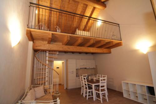 a loft apartment with a spiral staircase and a table at Agriturismo Cascina della Fontana in Lodi