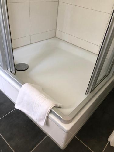 a bath tub with a towel on the side of it at MyCompass Hotel Offenbach in Offenbach