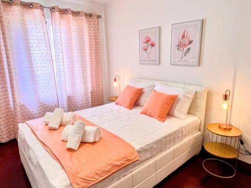 een slaapkamer met een groot wit bed met oranje kussens bij Stay In Madeira in Funchal