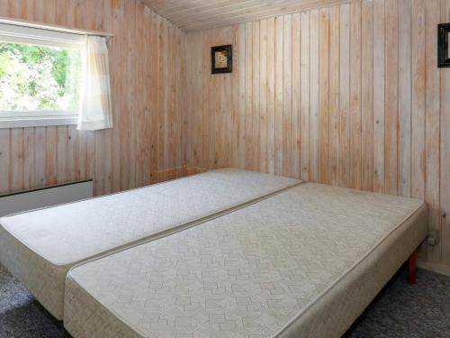 een slaapkamer met een bed in een houten muur bij Holiday home Storvorde XXIII in Storvorde