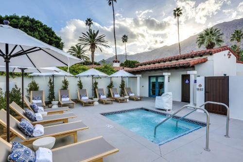 a hotel patio with a pool and lounge chairs at La Serena Villas, A Kirkwood Collection Hotel in Palm Springs