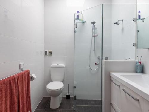 a bathroom with a shower and a toilet and a sink at Jamaica Mid-Century in Seaton