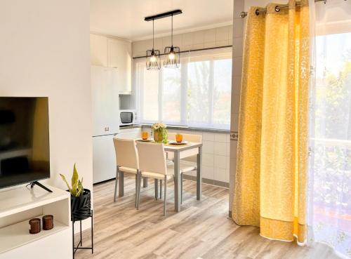 a kitchen and dining room with a table and yellow curtains at Stay In Madeira in Funchal