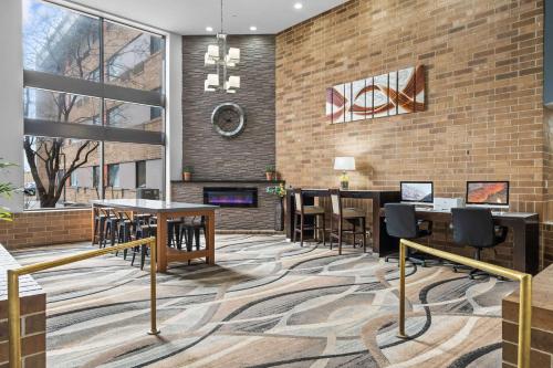a lobby with tables and chairs and a fireplace at Quality Inn & Suites Mall of America - MSP Airport in Bloomington