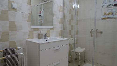 a white bathroom with a sink and a shower at Casa Bocage in Verdelho