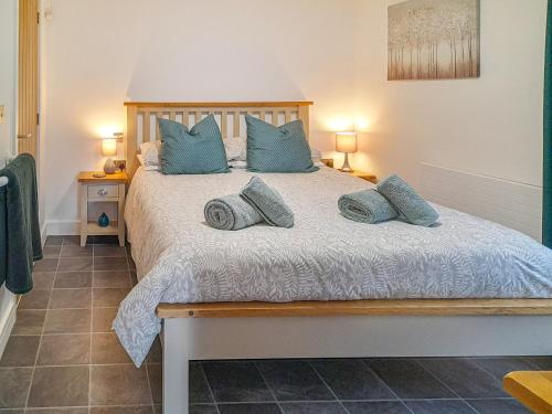 een slaapkamer met een groot bed met blauwe kussens bij The Harwell in Assington