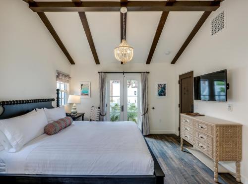 a bedroom with a large bed and a tv at La Serena Villas in Palm Springs