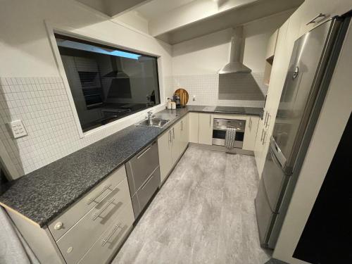 a small kitchen with a sink and a refrigerator at Private Water Front House in Whangaparaoa