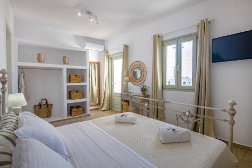 una camera bianca con letto e televisore di Arethousa House a Drios
