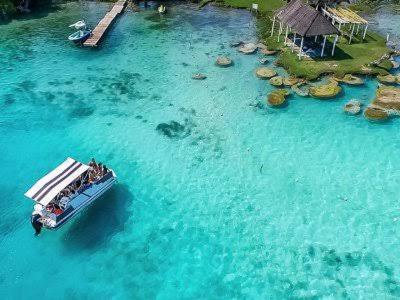 a boat in the water next to a resort at Tours in the lagun in Bacalar