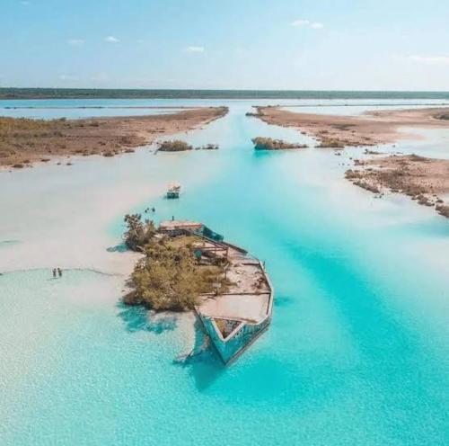 an island with a boat in a body of water at Tours in the lagun in Bacalar