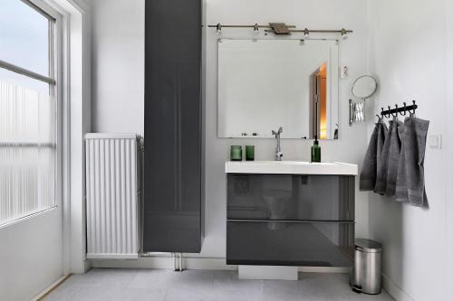 y baño con lavabo y espejo. en Guestly Homes - 4BR Charming Apartment, en Piteå