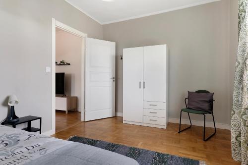 a bedroom with a bed and a chair in it at Guestly Homes - 4BR Charming Apartment in Piteå