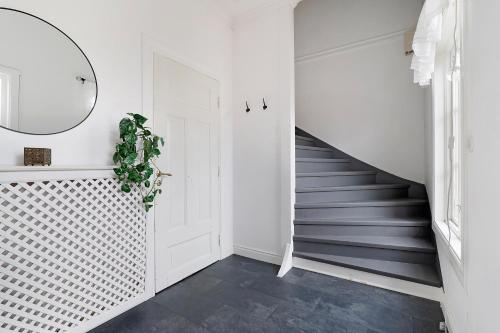 a hallway with a staircase and a mirror at Guestly Homes - 4BR Charming Apartment in Piteå