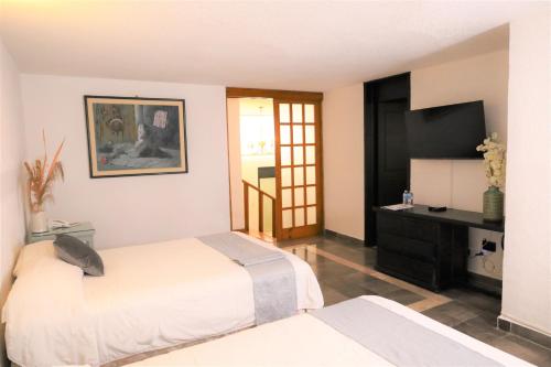 a bedroom with a bed and a dresser in it at Hotel Grand Vista Cuernavaca in Cuernavaca