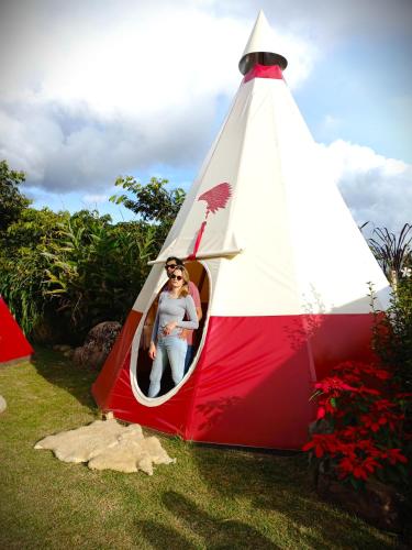 a woman is inside of a red and white tent at BIOSFERA LODGE GLAMPING tipi 2 personas in Oxapampa