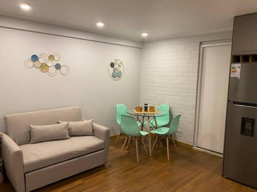 a living room with a couch and a table with chairs at Lindo Apartamento, full equipado -Factura empresas- in Quillota