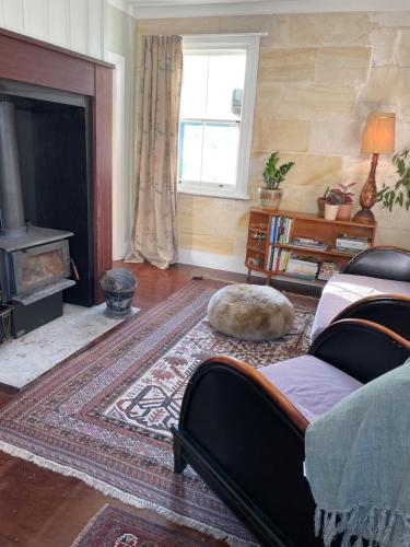 a living room with a couch and a fireplace at Heritage Hideaway in Oamaru