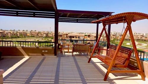 a porch with two benches and a swing at Chalet Marina Wadi Degla Families Only Pool view 2nd floor with Roof 6 adults in Ain Sokhna