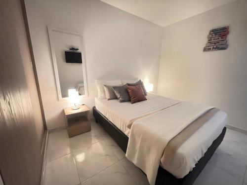 a white bedroom with a bed with a night stand at Amplio y Lujoso Apartamento en Jamundí in Jamundí