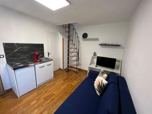 uma sala de estar com um sofá azul e uma cozinha em My casa 2 em Choisy-le-Roi