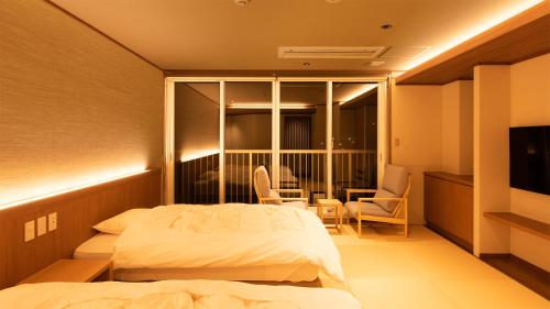 a hotel room with two beds and a television at Fukusenka in Ukiha
