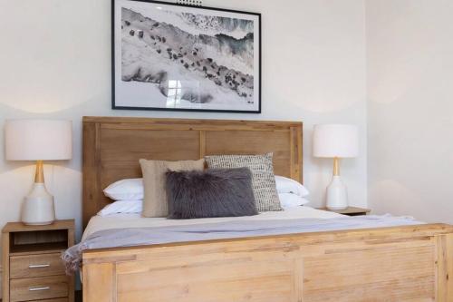 een slaapkamer met een houten bed met 2 lampen bij Newly Reburbished Sydney Harbourfront Boathouse Escape in Sydney
