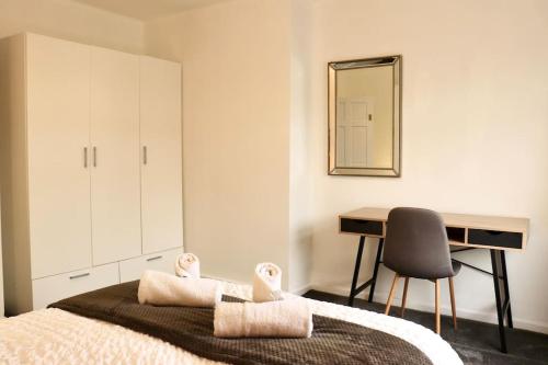 een slaapkamer met een bed, een bureau en een spiegel bij Charming 3 Bedroom Property FREE WiFi & Parking in Beeston