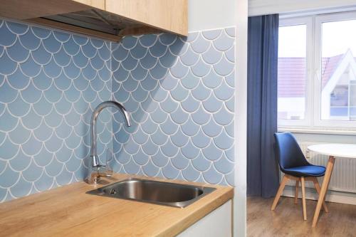 a kitchen with a sink and a blue wall at Blue Apartment Gdańsk in Gdańsk