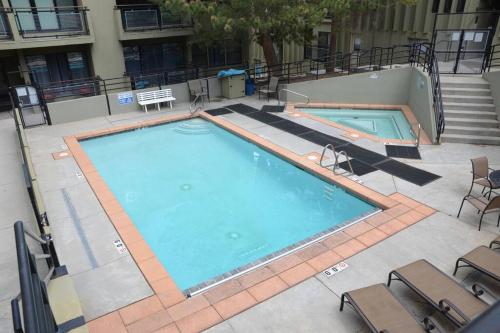 Elle offre une vue sur la grande piscine bordée de chaises. dans l'établissement Premier Ski & City Escape: Upscale 2BR Condo in Downtown Park City, à Park City