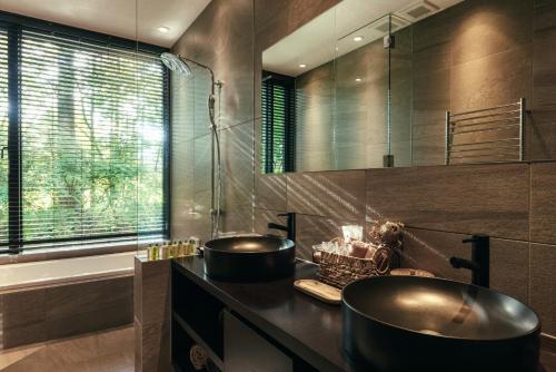輕井澤的住宿－La Maison Karuizawa，浴室配有2个盥洗盆和1个浴缸。