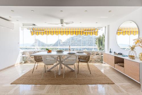 - une cuisine avec une table à manger et des chaises dans l'établissement Grand 4 pièces 6 personnes fabuleuse vue mer clim garage, à Villeneuve-Loubet