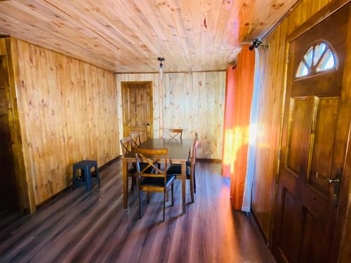 a wooden dining room with a table and chairs at Cabañas EMC in Los Vilos