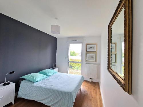 une chambre avec un lit et un miroir dans l'établissement Apartment in Concarneau near Seafront, à Concarneau