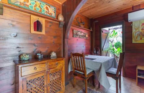 d'une salle à manger avec une table et un mur en bois. dans l'établissement Leu lagon, à Saint-Leu