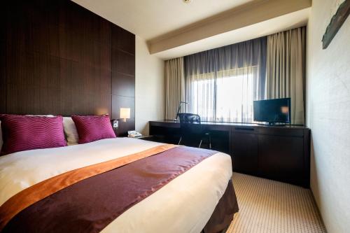 a hotel room with a large bed and a television at Hotel Metropolitan Edmont Tokyo in Tokyo