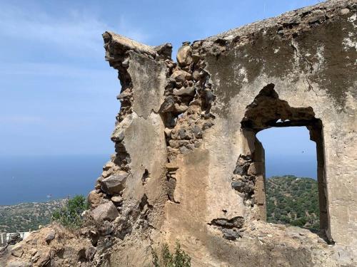 an old building with a window on a hill at Cloud House on Nisyros in Emporeiós