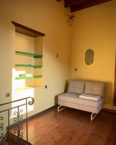 a living room with a couch in the corner of a room at Cloud House on Nisyros in Emporeiós
