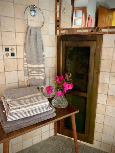 a table with towels and a vase of flowers on it at Cloud House on Nisyros in Emporeiós
