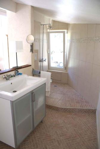 une salle de bain avec un lavabo blanc et une douche dans l'établissement Manor Norbert, à Ventenac-Cabardès