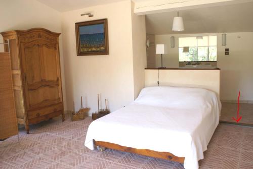 1 dormitorio con cama blanca y armario de madera en Manor Norbert, en Ventenac-Cabardès