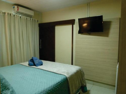 a bedroom with a bed and a flat screen tv at Pousada Marlin Azul in Fernando de Noronha